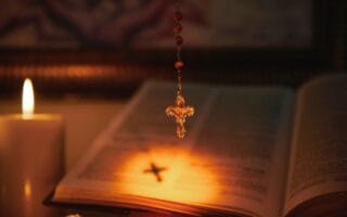 Imagem da Bíblia Sagrada com terço, segundo a doutrina católica