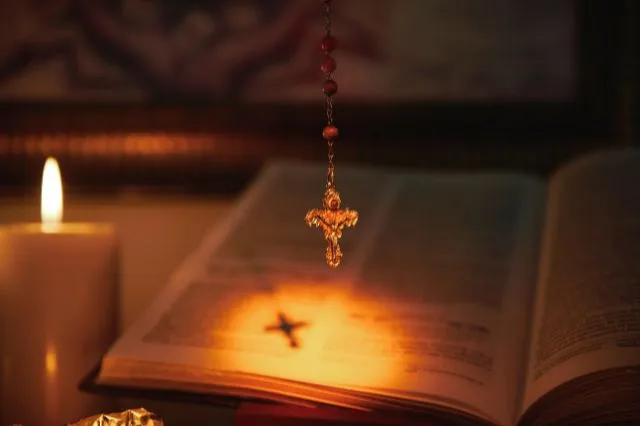 Imagem da Bíblia Sagrada com terço, segundo a doutrina católica