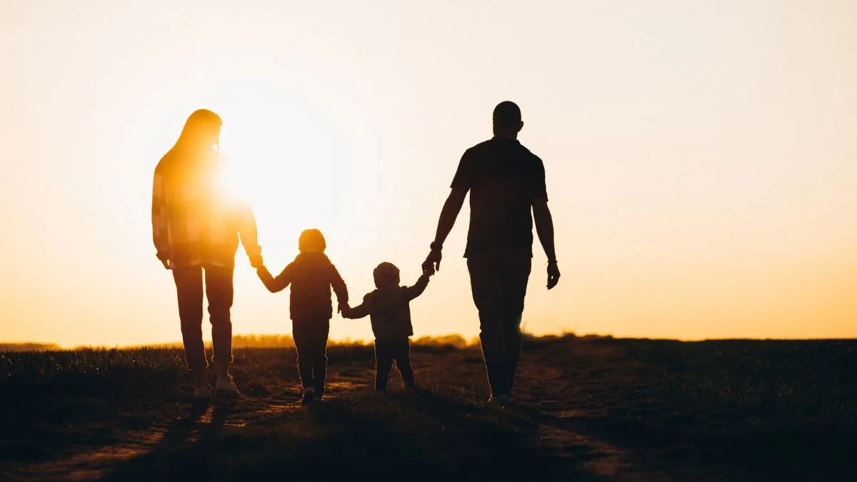 “Encontro de Catequese sobre Vocações: família caminhando de mãos dadas ao pôr do sol, simbolizando o chamado de Deus à santidade.”
