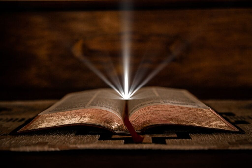 Bíblia aberta com uma luz saindo dela, representando a Palavra de Deus iluminando nossas vidas